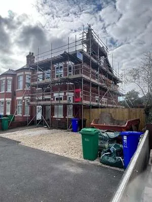 Full scaffold around a large red-brick semi-detached house