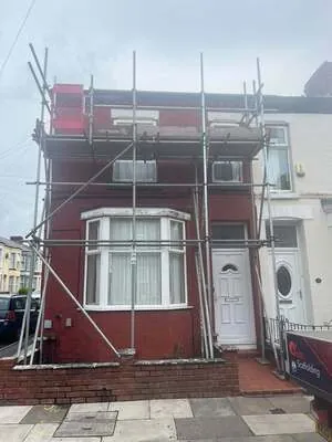 Scaffolding on a red-brick terraced house with a bay window
