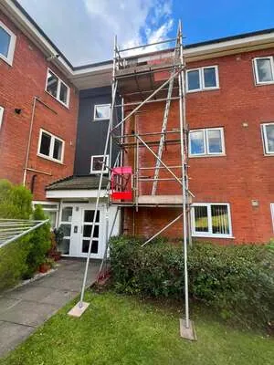 Scaffold tower against a modern brick apartment block