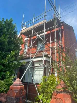 Scaffolding on an Edwardian red-brick house with a bay window