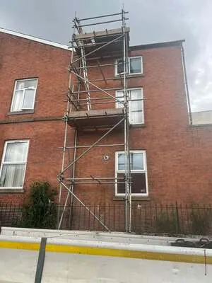 Scaffold tower on the side of a three-storey brick building