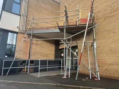 Scaffolding over the entrance of a modern brick apartment building