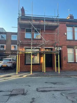 Scaffolding above a shopfront on a three-storey brick building