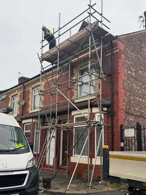 Scaffolder working at height on an end-terrace house scaffold